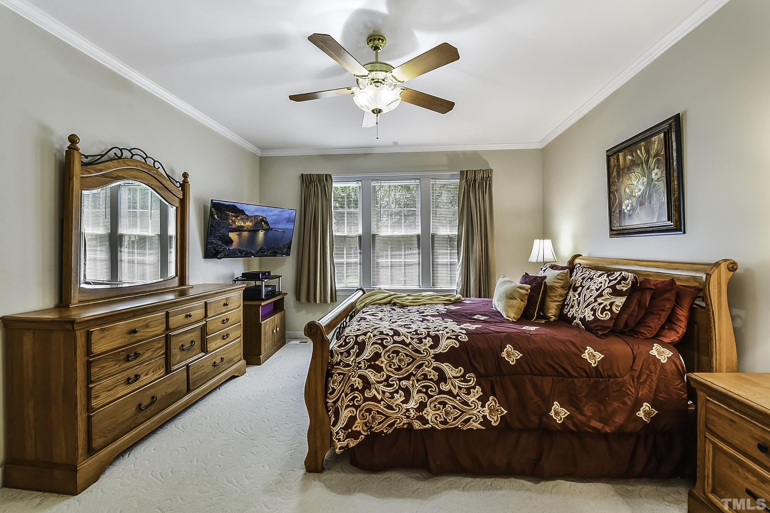 7929 Milltrace Run Raleigh, NC 27615 - Photo 17 of 36 a bedroom with a bed a dresser and next to a window