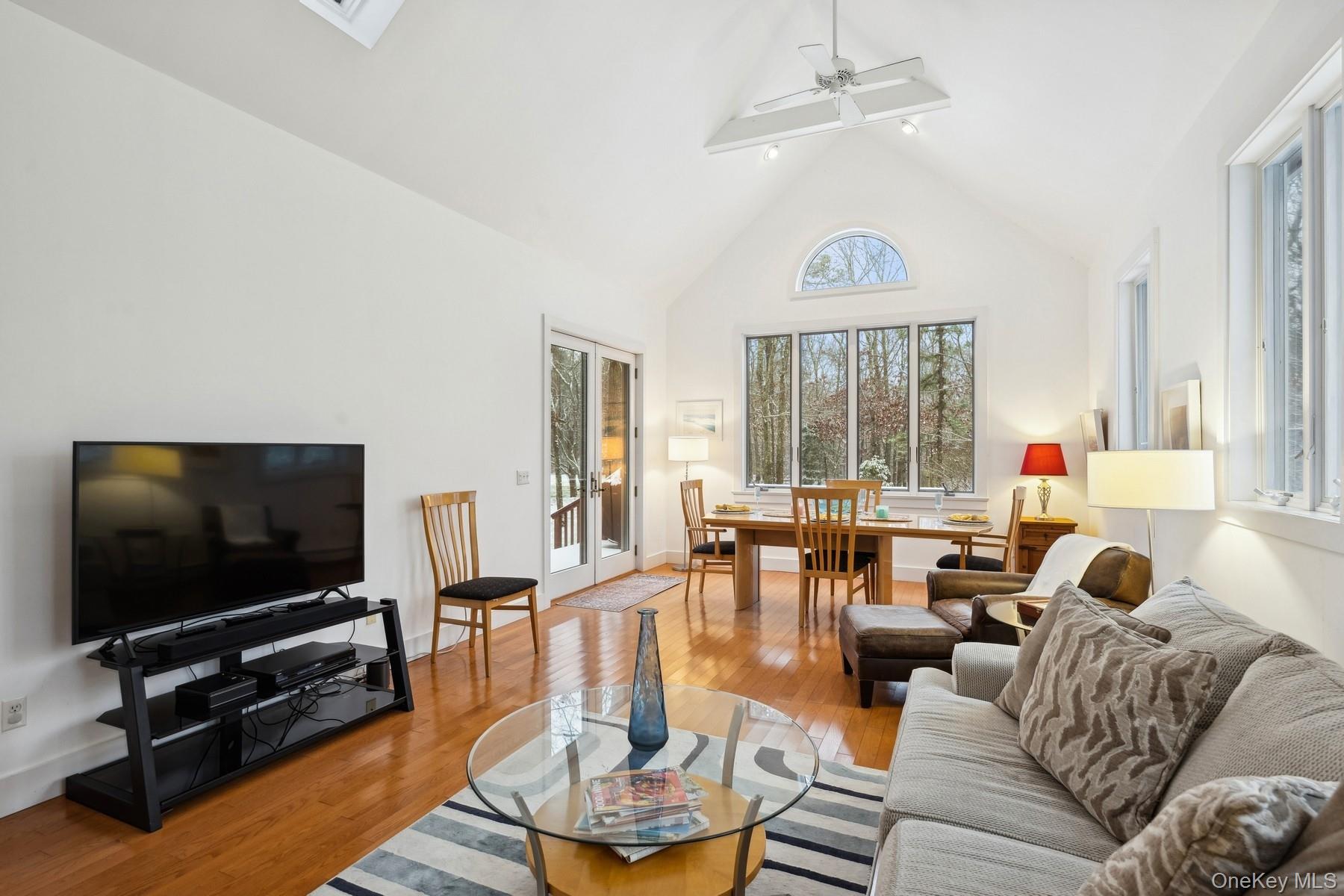 12 Hildreth Road Hampton Bays, NY 11946 - Photo 9 of 21 Living room featuring beamed ceiling, high vaulted ceiling, light hardwood / wood-style flooring, and ceiling fan