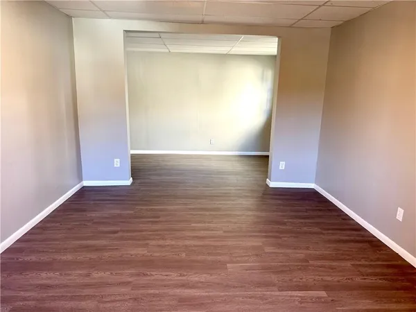 a view of empty room with wooden floor