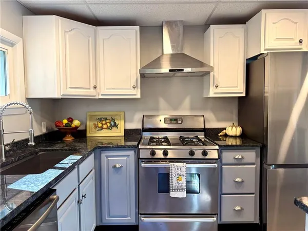 a kitchen with granite countertop a stove sink and cabinets