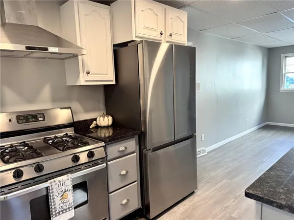 a kitchen with stainless steel appliances granite countertop a refrigerator and a stove