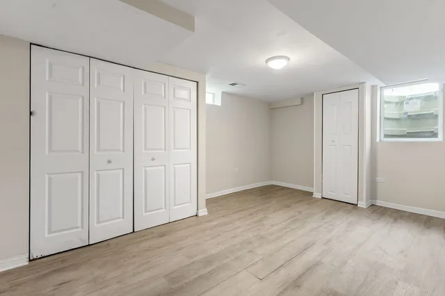 an empty room with wooden floor and closet area