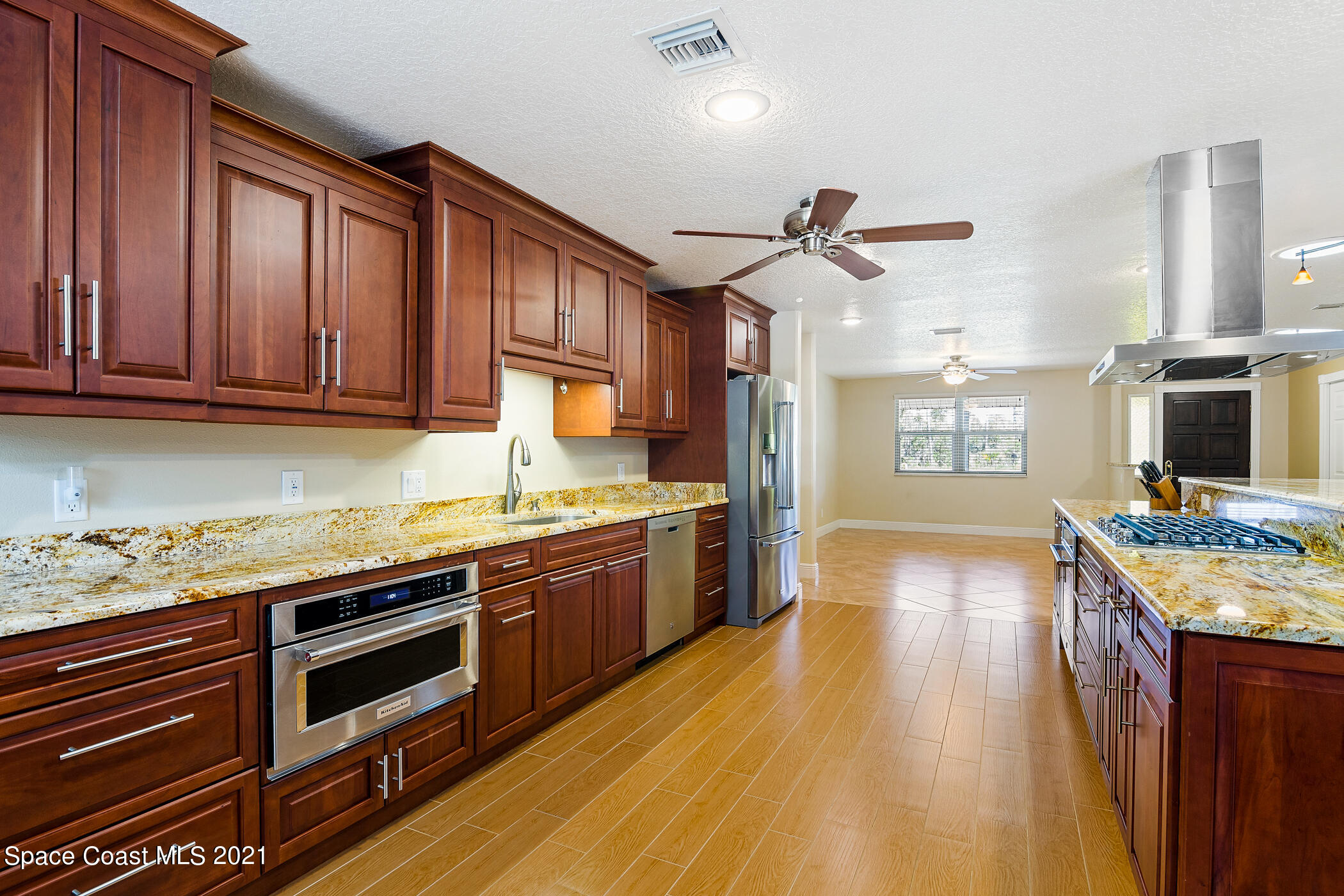 1390 Friday Road Cocoa, FL 32926 - Photo 15 of 69 a kitchen with stainless steel appliances granite countertop wooden cabinets a stove top oven a sink and dishwasher