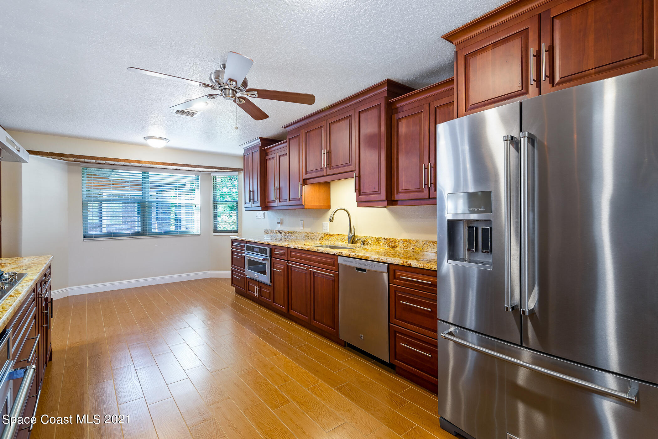 1390 Friday Road Cocoa, FL 32926 - Photo 16 of 69 a kitchen with stainless steel appliances granite countertop a refrigerator a stove and a wooden floors