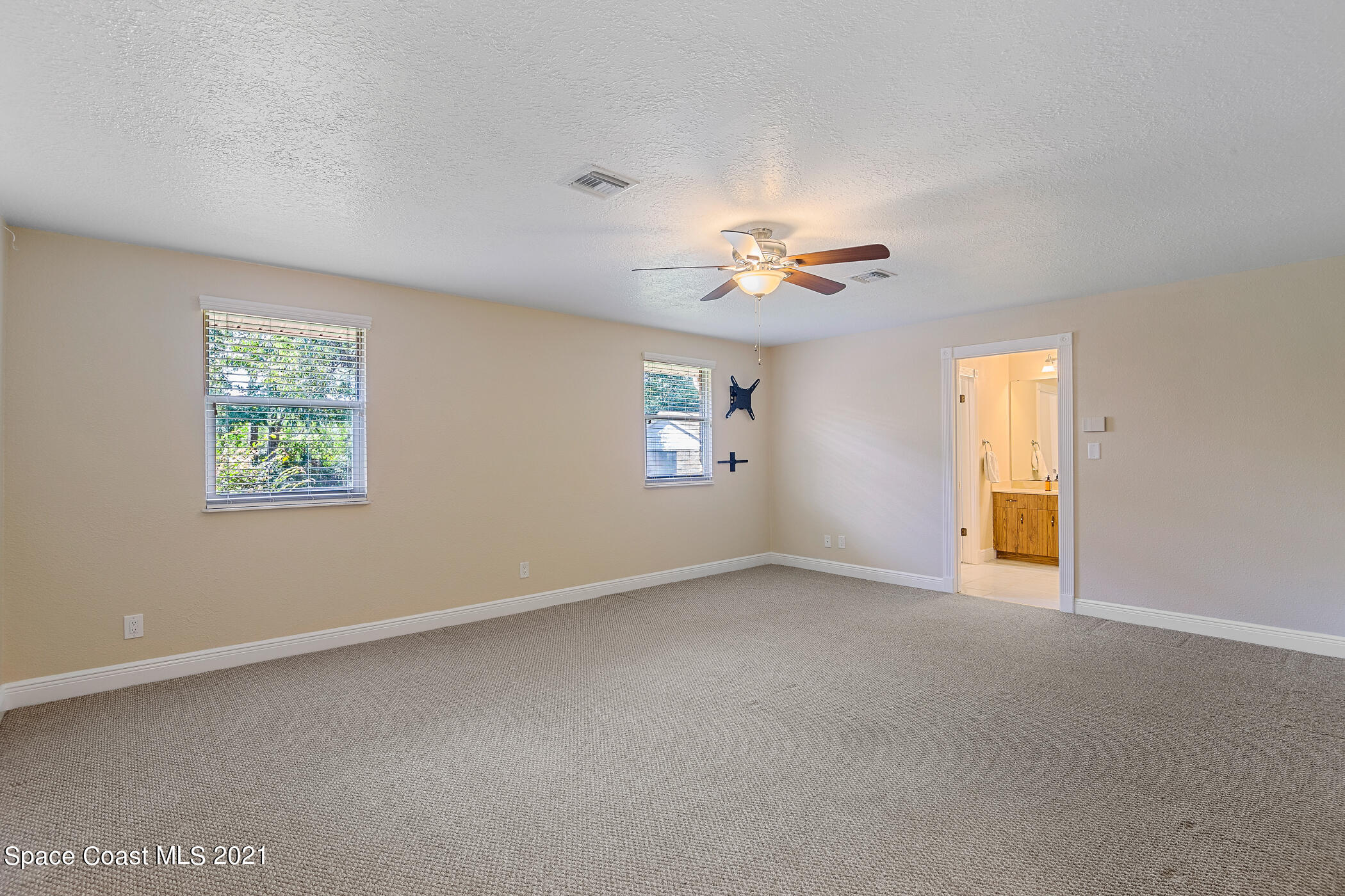 1390 Friday Road Cocoa, FL 32926 - Photo 23 of 69 an empty room with windows and chandelier fan