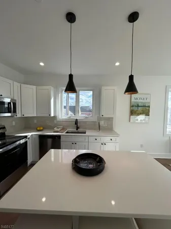 a kitchen with a sink a stove and chairs
