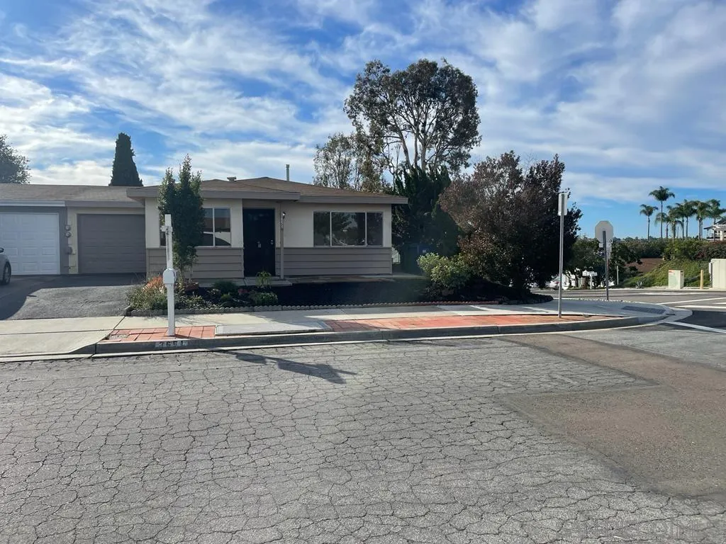 a front view of a house with a yard and trees