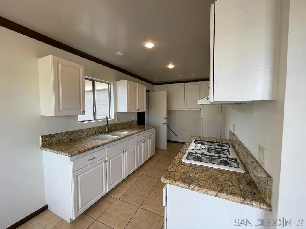 3651 North Way Oceanside, CA 92056 - Photo 2 of 16 a kitchen with granite countertop sink stove and cabinets