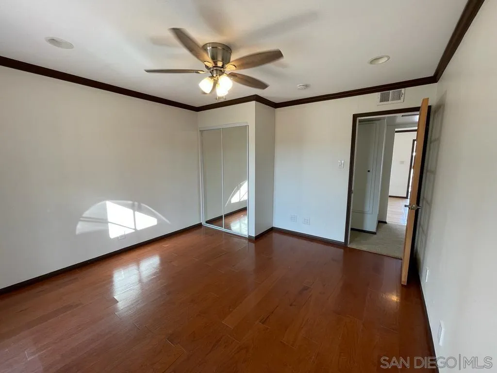 3651 North Way Oceanside, CA 92056 - Photo 7 of 16 an empty room with wooden floor chandelier fan and windows