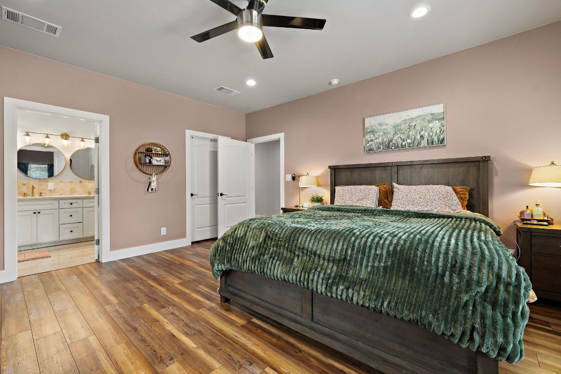 611 Elliott Street Taylor, TX 76574 - Photo 15 of 29 a bedroom with a large bed and a chandelier