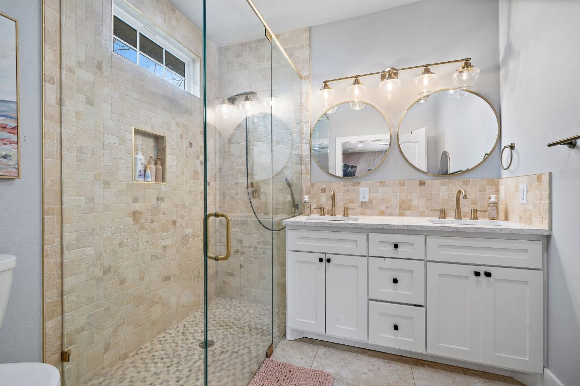 611 Elliott Street Taylor, TX 76574 - Photo 16 of 29 a bathroom with a double vanity sink mirror and shower