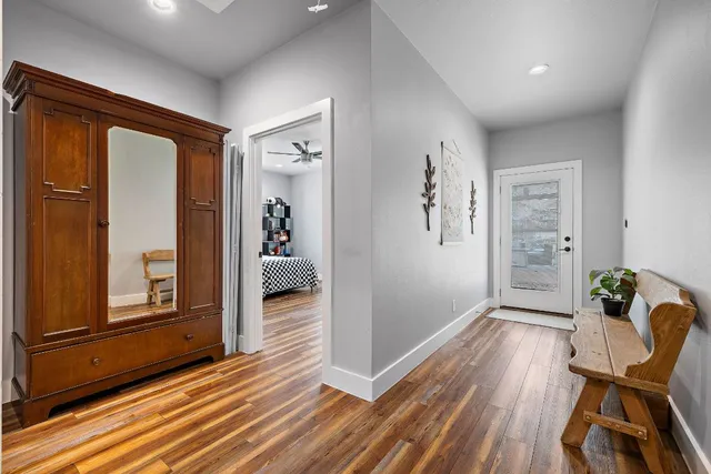 a hallway with wooden floor and furniture