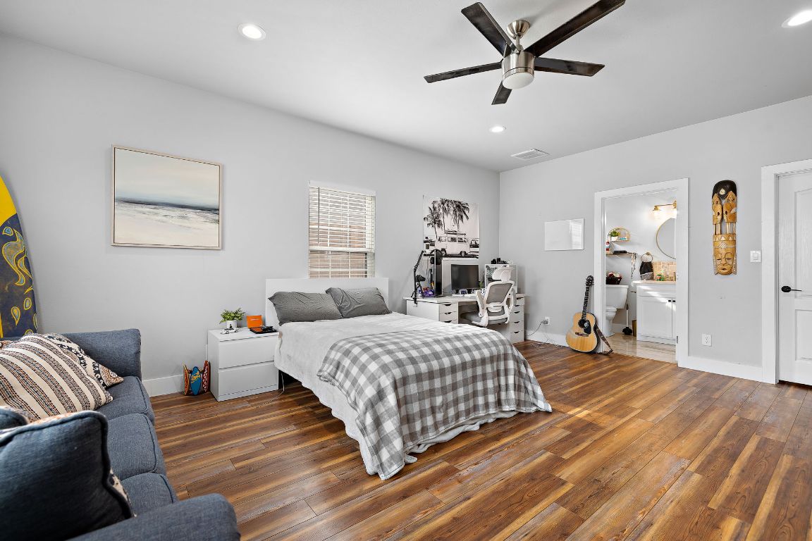 611 Elliott Street Taylor, TX 76574 - Photo 22 of 29 a bedroom with a bed and wooden floor