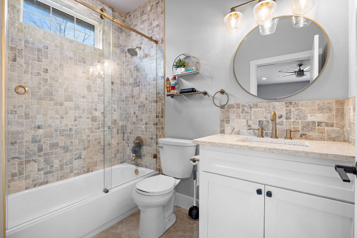 611 Elliott Street Taylor, TX 76574 - Photo 23 of 29 a bathroom with a sink a toilet and a mirror