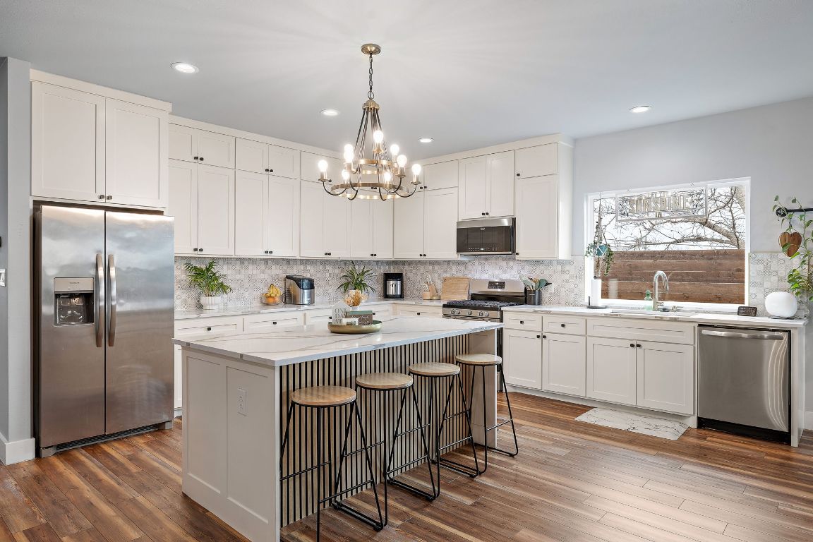 611 Elliott Street Taylor, TX 76574 - Photo 4 of 29 a kitchen with kitchen island granite countertop appliances cabinets and a center island