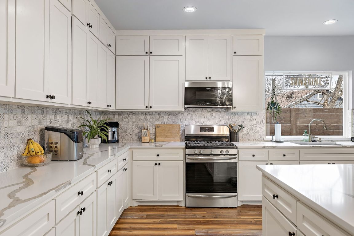 611 Elliott Street Taylor, TX 76574 - Photo 5 of 29 a kitchen with stainless steel appliances white cabinets sink and a stove