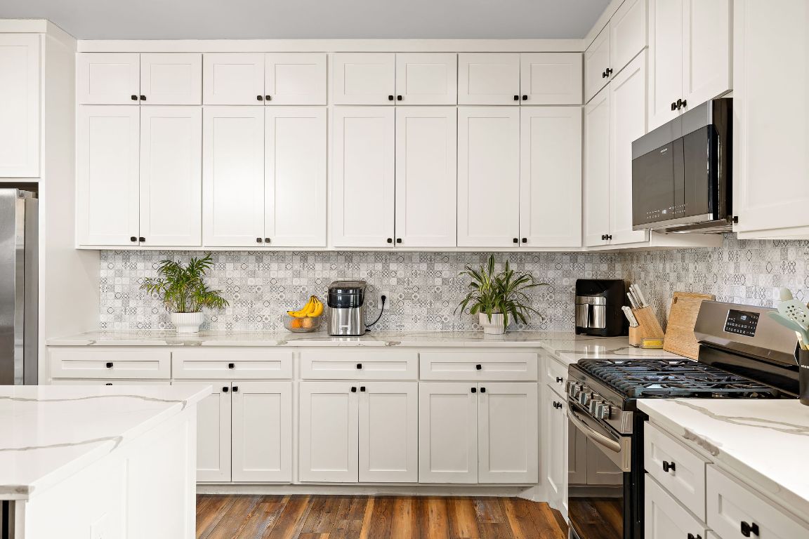 611 Elliott Street Taylor, TX 76574 - Photo 7 of 29 a kitchen with stainless steel appliances granite countertop a stove a sink and white cabinets