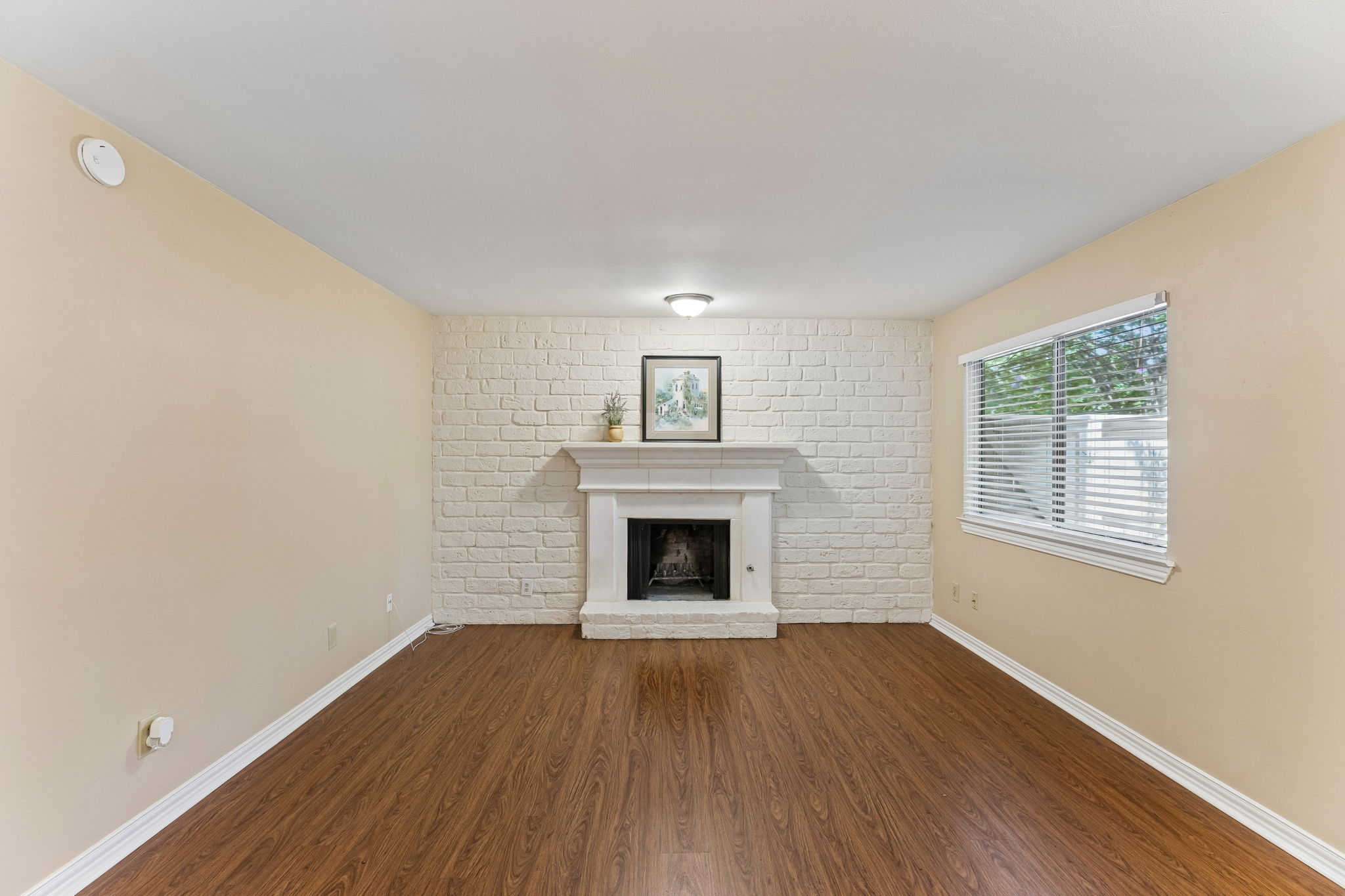 8340 Fathom Circle, Unit 103 Austin, TX 78750 - Photo 4 of 30 an empty room with wooden floor windows and a fireplace