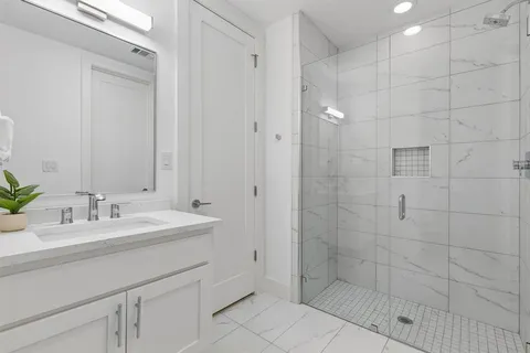 a bathroom with a double sink shower and a mirror