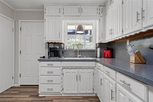 a kitchen with a refrigerator and white cabinets
