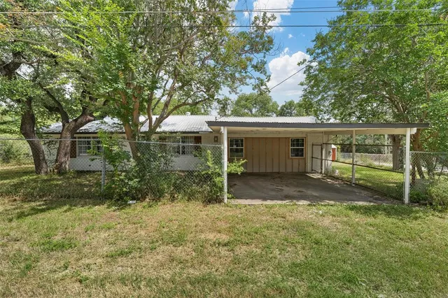 a front view of a house with a yard and trees