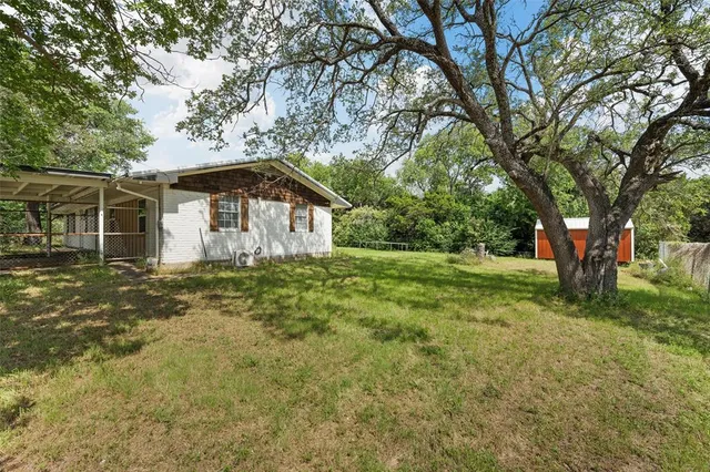a backyard of a house with a table and chairs