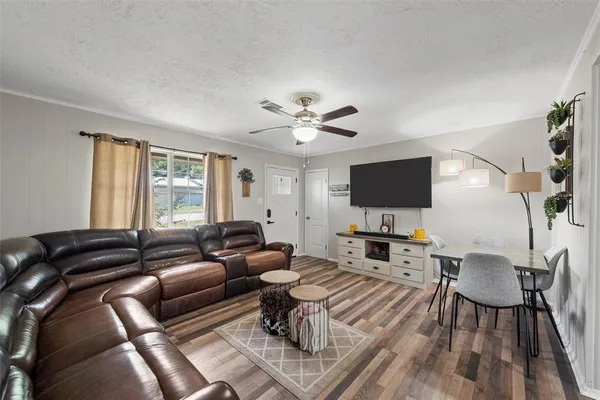 a living room with furniture a flat screen tv and a window