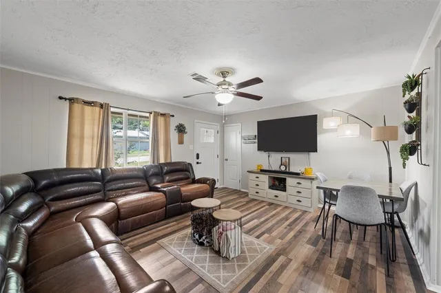 a living room with furniture a flat screen tv and a window