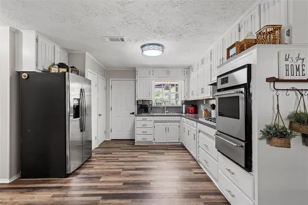 a kitchen with sink refrigerator and cabinets
