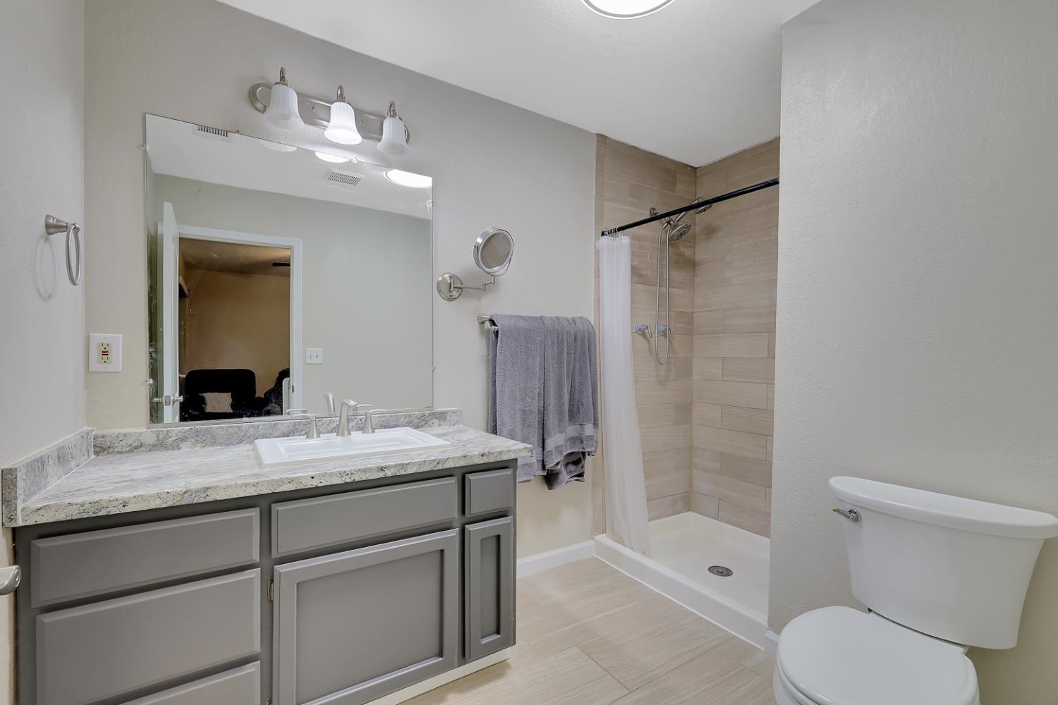 2130 Palm Street Sutter, CA 95982 - Photo 12 of 27 a bathroom with a granite countertop sink toilet mirror and shower