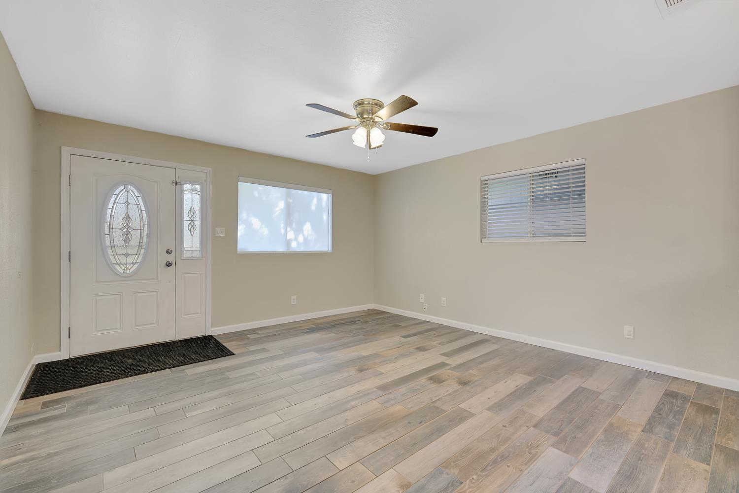 2130 Palm Street Sutter, CA 95982 - Photo 3 of 27 an empty room with wooden floor chandelier fan and windows