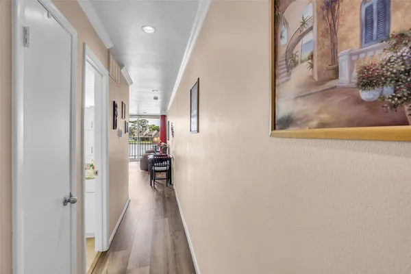 a view of a hallway with wooden floor and a living room