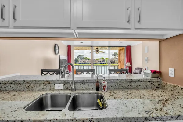 a kitchen sink with granite countertop a sink and a window
