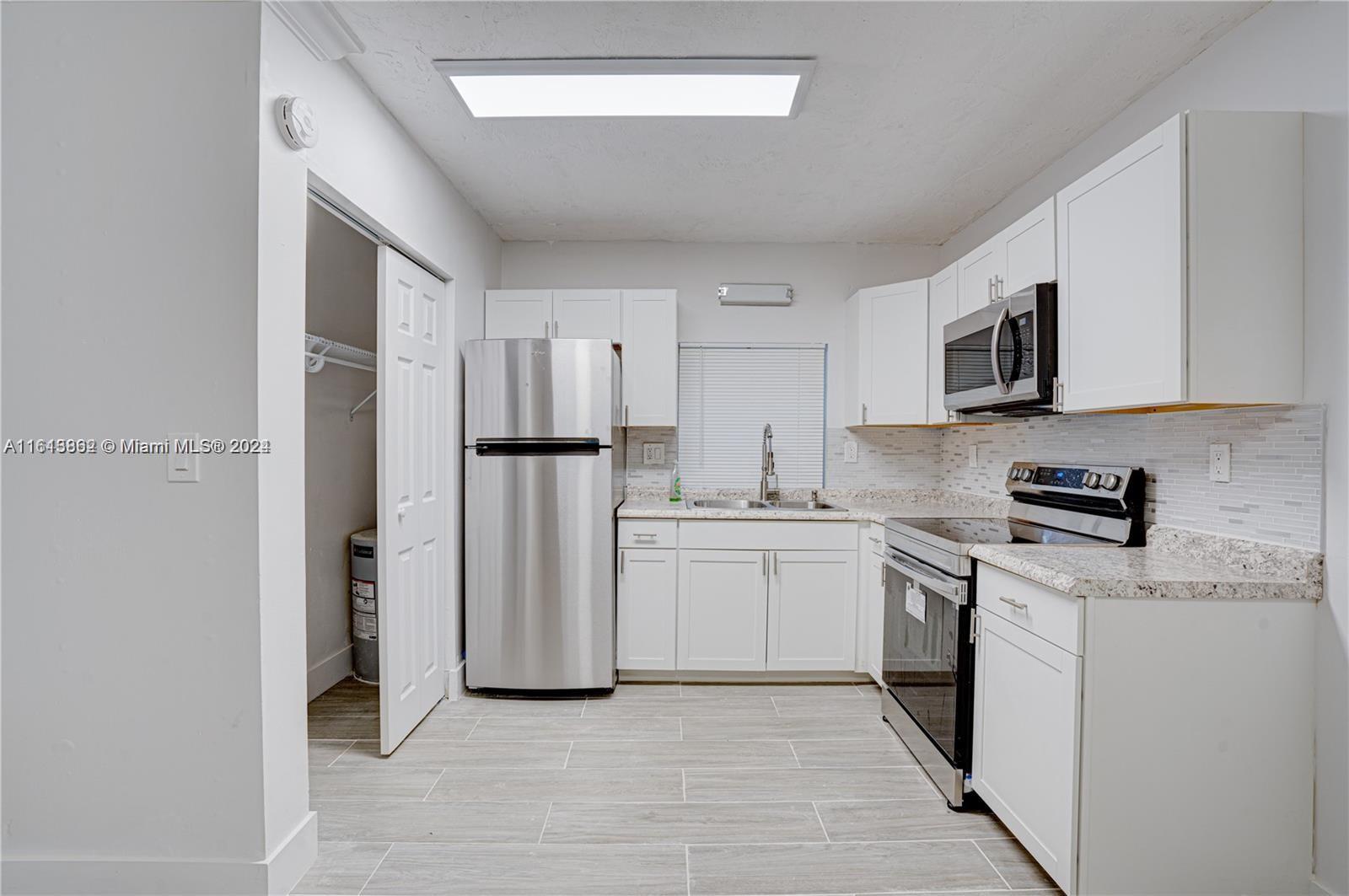 3019 Southwest 68th Terrace, Unit 6 Miramar, FL 33023 - Photo 1 of 10 a kitchen with stainless steel appliances granite countertop a refrigerator sink and stove