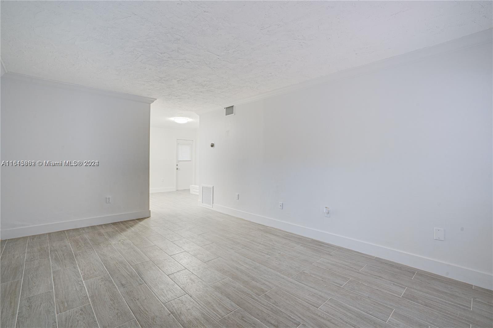 3019 Southwest 68th Terrace, Unit 6 Miramar, FL 33023 - Photo 4 of 10 a view of an empty room and wooden floor