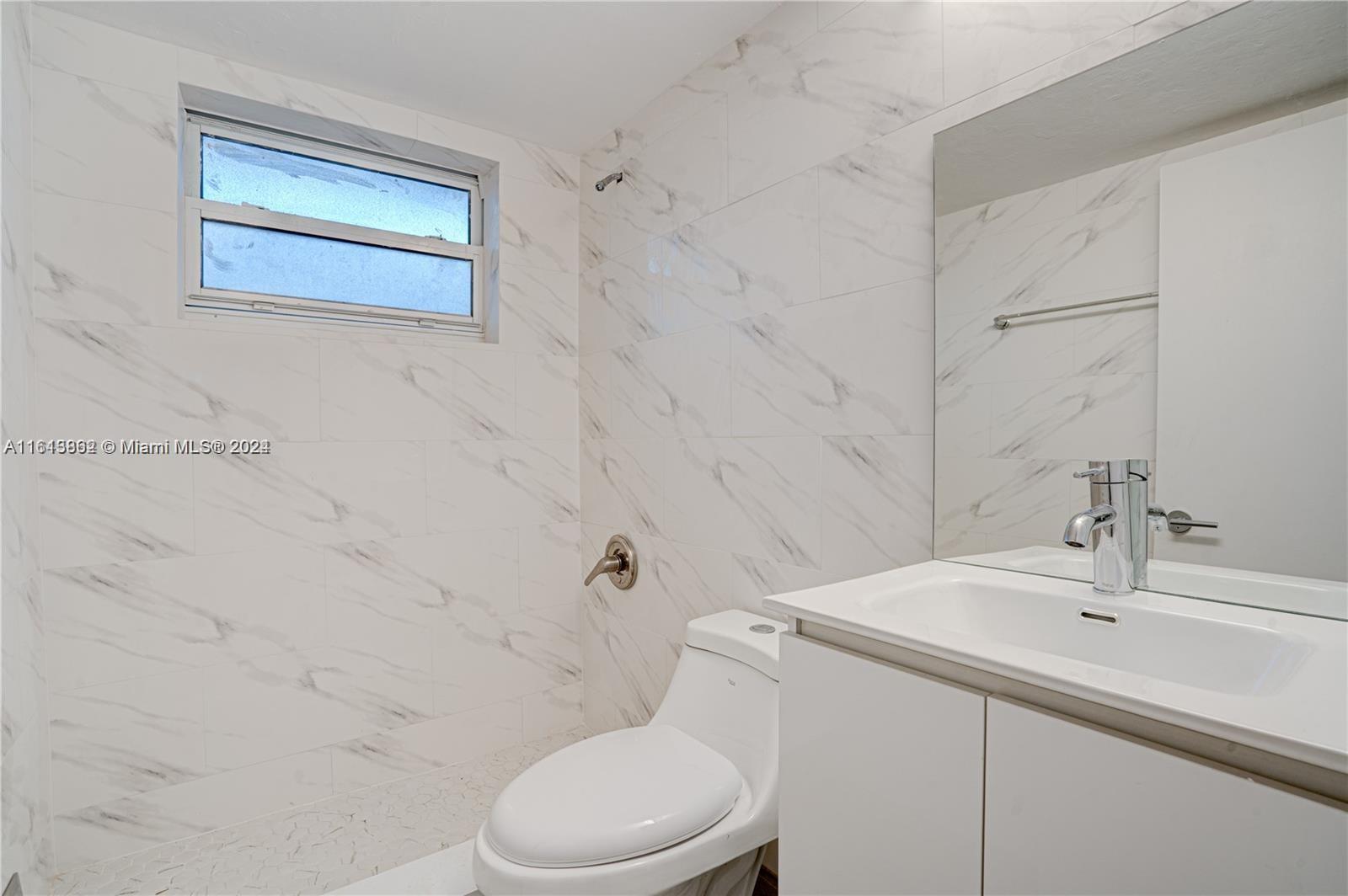 3019 Southwest 68th Terrace, Unit 6 Miramar, FL 33023 - Photo 6 of 10 a bathroom with a sink a toilet and shower