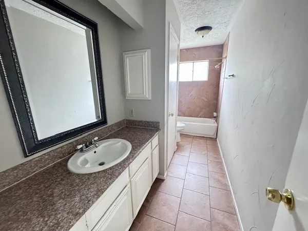 a bathroom with a granite countertop sink and a mirror