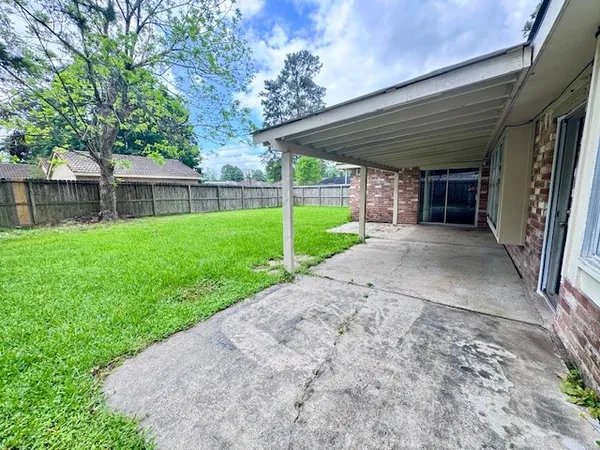 a view of a house with a yard and large tree