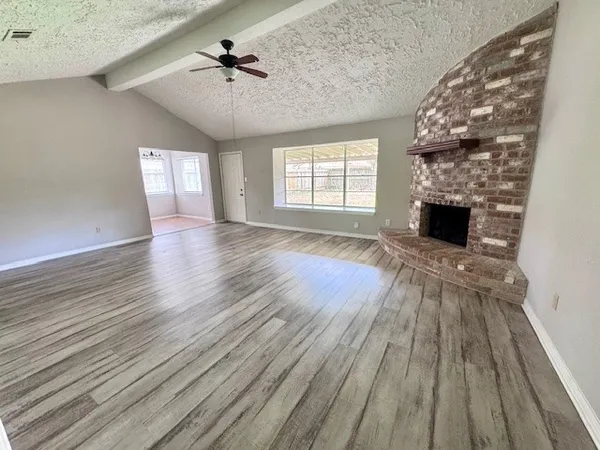 wooden floor fireplace and natural light in room
