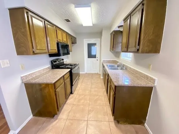 a kitchen with a sink a stove top oven and a sink