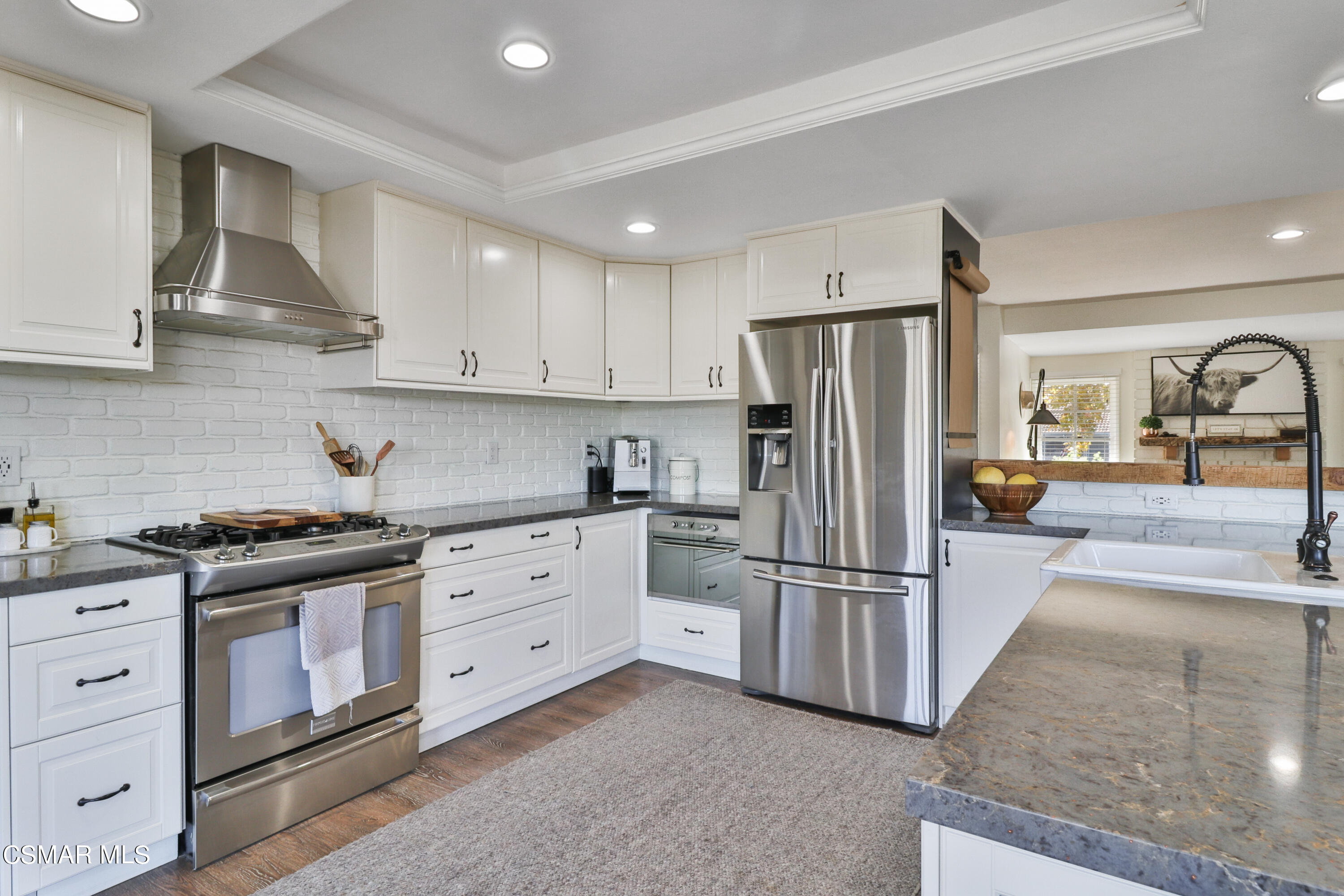 1193 Nonchalant Drive Simi Valley, CA 93065 - Photo 38 of 82 a kitchen with stainless steel appliances granite countertop a refrigerator stove and white cabinets