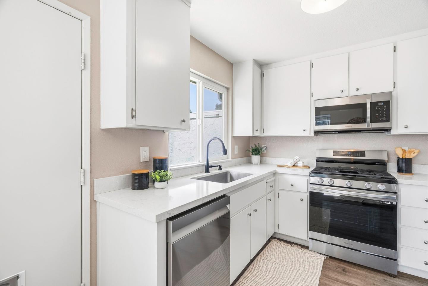 297 Perch Way Aptos, CA 95003 - Photo 12 of 42 a kitchen with white cabinets stainless steel appliances and sink