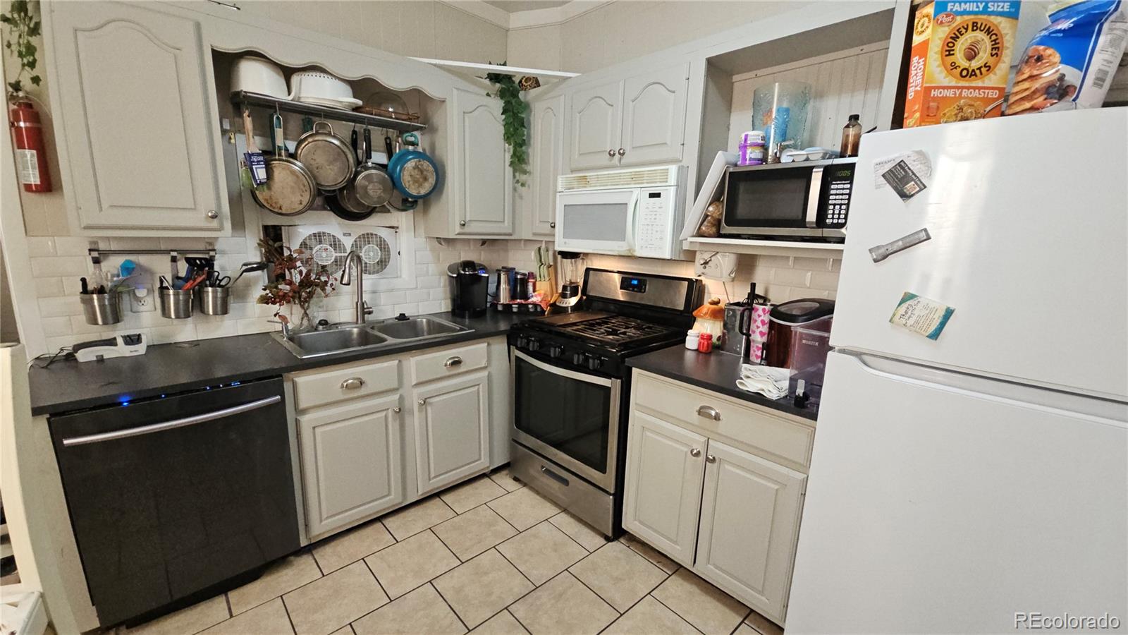 402 East Routt Avenue Pueblo, CO 81004 - Photo 3 of 9 a kitchen with white cabinets and white appliances
