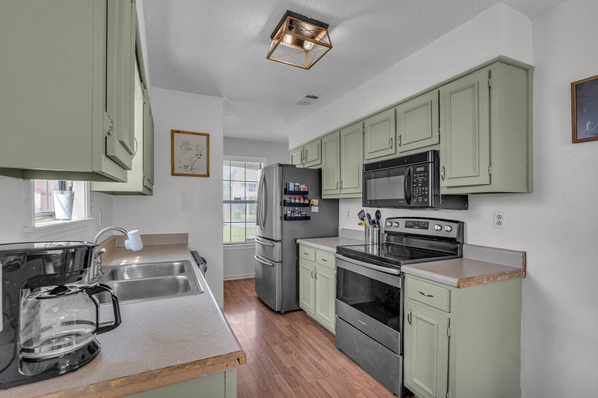 4331 Water Briar Road Millington, TN 38053 - Photo 11 of 29 Kitchen with stainless steel appliances, light wood-style floors, visible vents, green cabinetry, and a sink