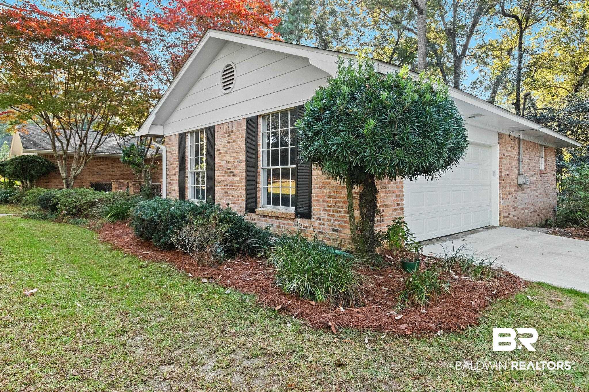 752 Evergreen Street Fairhope, AL 36532 - Photo 90 of 100 View of property exterior with a yard, brick siding, a garage, and concrete driveway