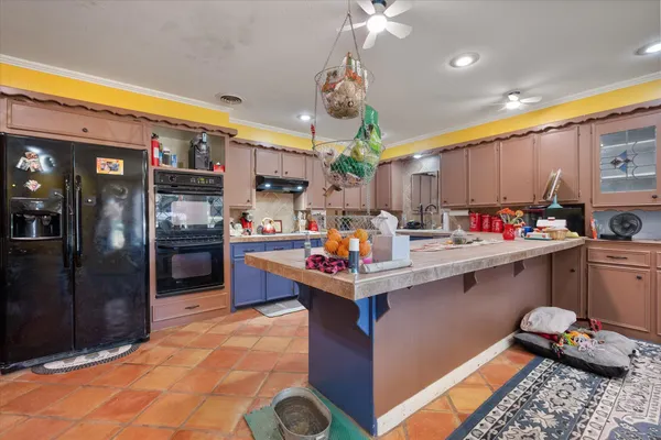 a kitchen with kitchen island granite countertop a sink counter top space appliances and cabinets
