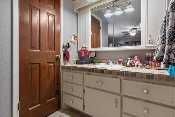 a bathroom with a granite countertop sink and a mirror