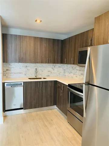 a kitchen with a refrigerator sink and cabinets