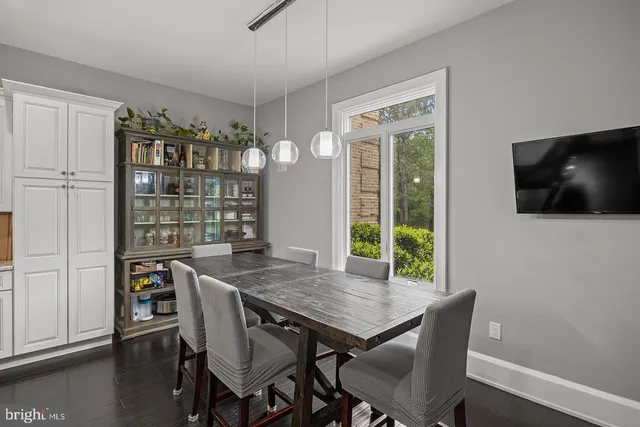 a kitchen with stainless steel appliances granite countertop a stove a refrigerator a kitchen island a dining table and chairs