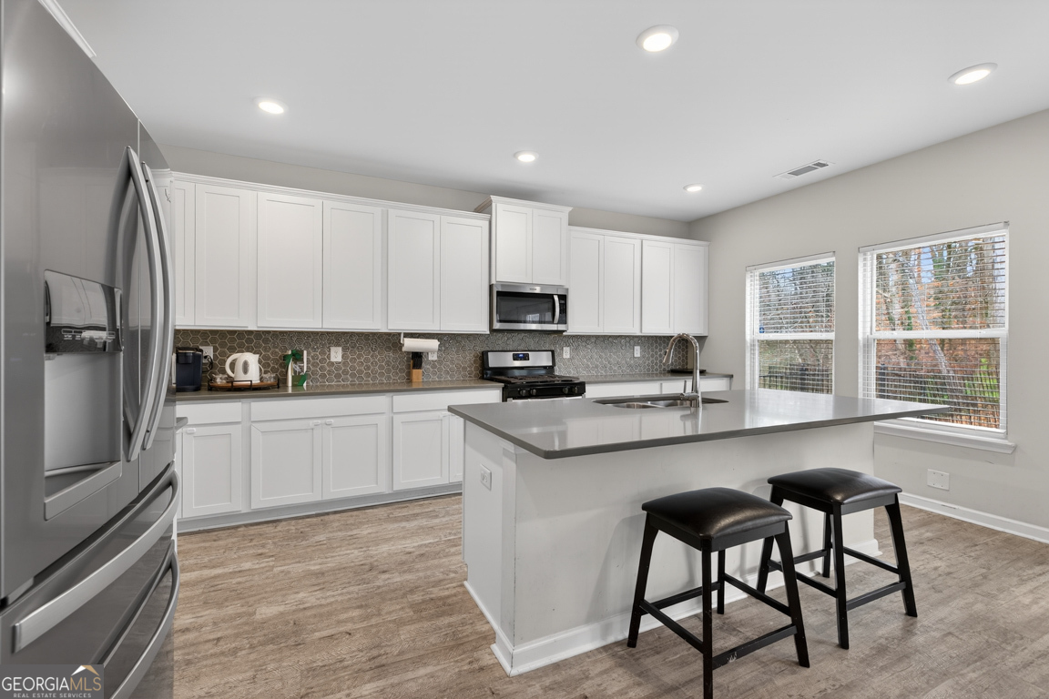 3511 Argent Way Marietta, GA 30008 - Photo 23 of 56 a kitchen with white cabinets and stainless steel appliances